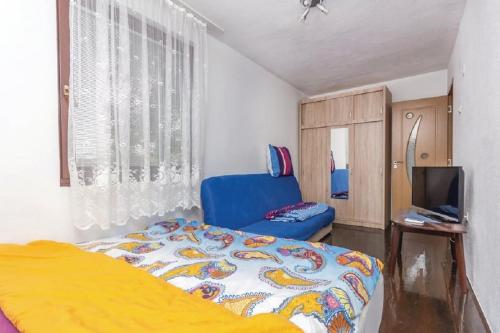 a bedroom with a bed and a blue chair at Holiday Home Lovric in Filipac