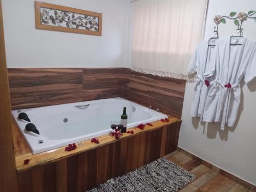a bath tub in a bathroom with a wooden floor at Recanto KAIRÓS in Visconde De Maua
