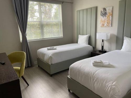 a hotel room with two beds and a desk and a window at Vista Cay Condo near Conventional Center Universal, See world, Disney 8 in Orlando