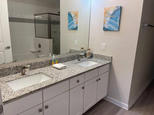 a bathroom with two sinks and a large mirror at Vista Cay Condo near Conventional Center Universal, See world, Disney 8 in Orlando