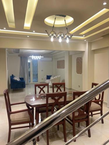 a dining room with a wooden table and chairs at Modern and spacious duplex الشيخ زايد in Sheikh Zayed
