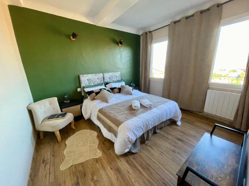 ein Schlafzimmer mit einem großen Bett und einer grünen Wand in der Unterkunft Détente parfumée, capitale du parfum in Grasse