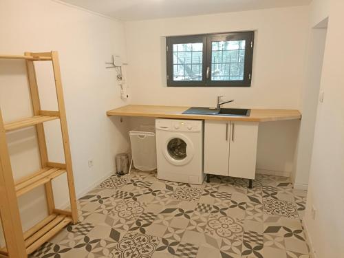 a laundry room with a sink and a washing machine at La maison du bois, 10 minutes de l'A71, 10 minutes de Bourges in Plaimpied-Givaudins