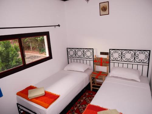 2 camas en una habitación con ventana en petite jolie maison vue sur lac, en Bine el Ouidane