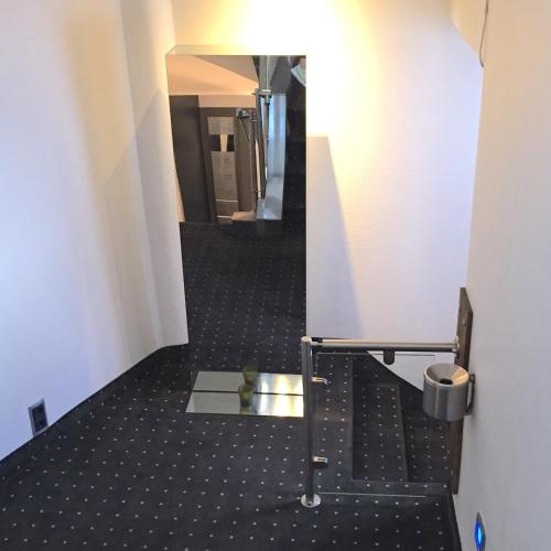 a hallway with a mirror in a building at Business Wieland Hotel in Düsseldorf