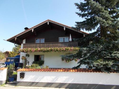 a house with a balcony with flowers on it at Karl-Stieler-Str. ONE ROOM in a 2 ROOM APPARTMENT ; LOT SPACE in Bruckmühl