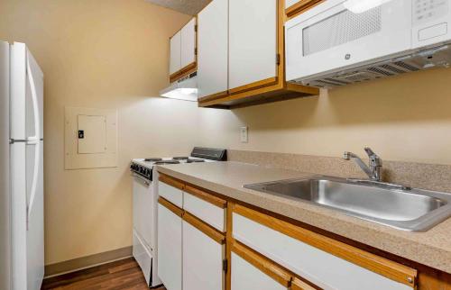 a kitchen with a sink and a white refrigerator at Extended Stay America Suites - Cincinnati - Blue Ash - Reagan Hwy in Blue Ash
