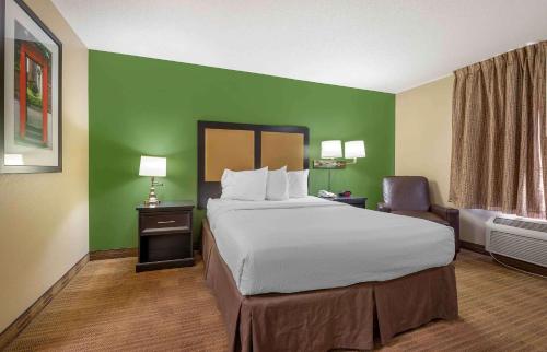 Habitación de hotel con cama y silla en Extended Stay America Suites - Fort Wayne - South, en Fort Wayne