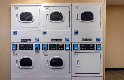 four washing machines are lined up against a wall at Extended Stay America Suites - Lexington - Nicholasville Road in Lexington