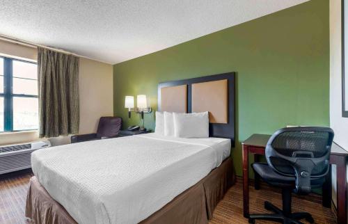 a hotel room with a bed and a desk and a chair at Extended Stay America Suites - Dallas - Greenville Avenue in Dallas
