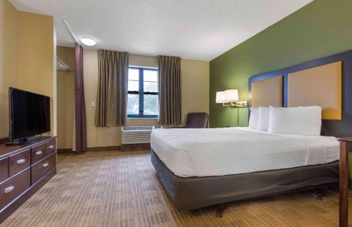 a hotel room with a bed and a flat screen tv at Extended Stay America Suites - Waco - Woodway in Waco