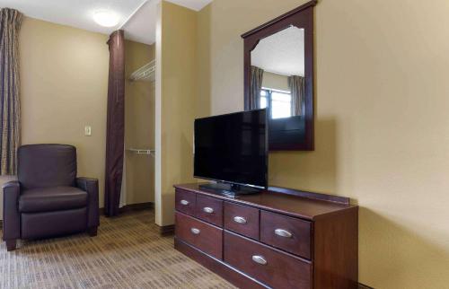 a room with a tv on a dresser and a chair at Extended Stay America Suites - Waco - Woodway in Waco