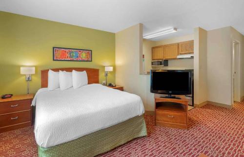 a hotel room with a bed and a flat screen tv at Extended Stay America Suites - Newport News - Yorktown in Newport News