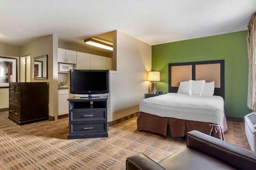 a bedroom with a bed and a flat screen tv at Extended Stay America Suites - Fort Worth - Fossil Creek in Fort Worth