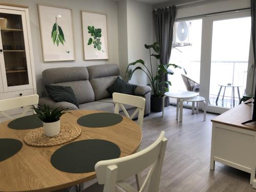 uma sala de estar com uma mesa e um sofá em Apartamento Vicaño - PLAYA SILGAR em Sanxenxo