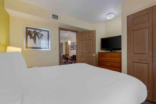 a bedroom with a white bed and a flat screen tv at Extended Stay America Suites - Chicago - Elgin - West Dundee in West Dundee