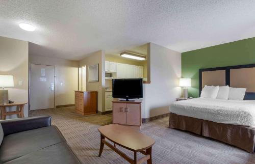 a hotel room with a bed and a flat screen tv at Extended Stay America Suites - Fort Worth - Southwest in Fort Worth