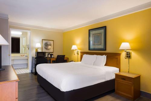 a hotel room with a large white bed and yellow walls at Econo Lodge in Savannah