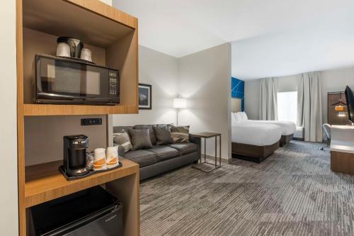 Habitación de hotel con sofá y cama en Comfort Inn & Suites Gallatin - Nashville Metro en Gallatin