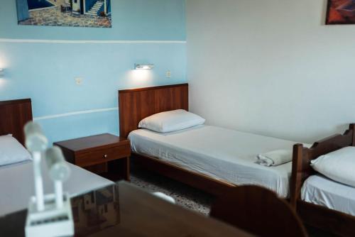 a small room with two beds and a table at Katerina Studios & Apartments in Sidari