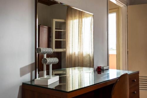 a dressing table with a mirror and a lamp on it at Katerina Studios & Apartments in Sidari
