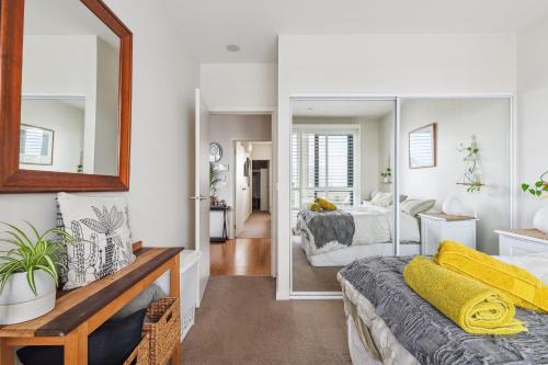 1 dormitorio con cama y espejo en Plantation Boho - 2BR 2BTHRM Northcote Abode, en Melbourne