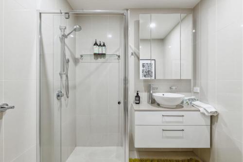 baño blanco con ducha y lavamanos en Plantation Boho - 2BR 2BTHRM Northcote Abode, en Melbourne