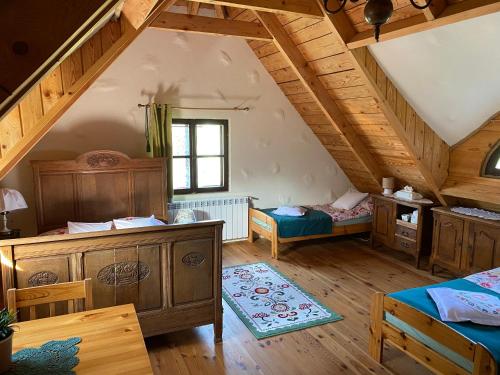 a attic room with two beds and wooden ceilings at Skansen Pomezania in Kałduny