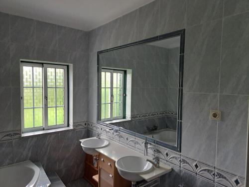 baño con 2 lavabos y espejo grande en Casa Pinho, en São Pedro do Sul