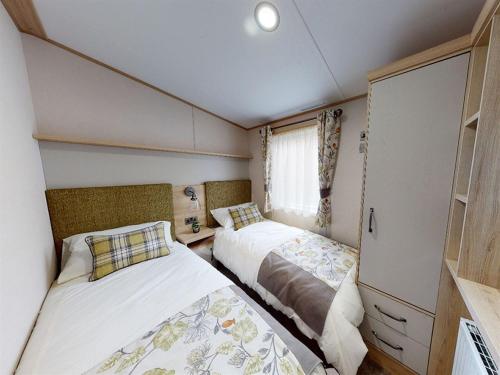 a small bedroom with two beds in a room at Holiday Home with Stunning Views in Newquay