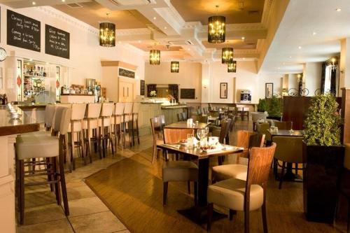 um restaurante com mesas e cadeiras e um bar em The Abbeyleix Manor Hotel em Abbeyleix