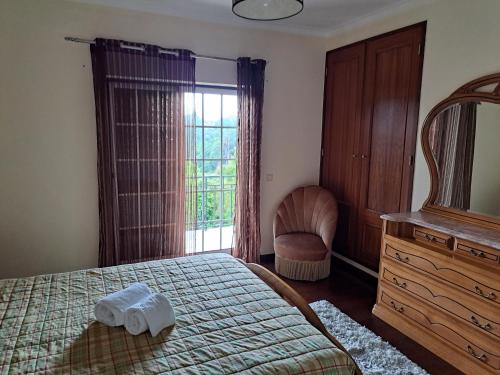 サン・ペードロ・ド・スーにあるCasa Pinhoのベッドルーム1室(ベッド1台、椅子、窓付)