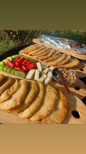 a table with a tray of food with meats and vegetables at Bujtina Oxhaku i Docit in Peshkopi