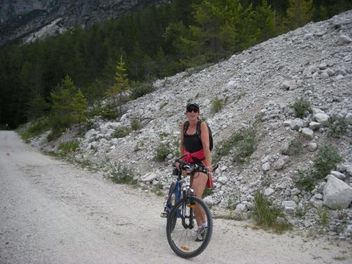 Eine Frau, die auf einer unbefestigten Straße Fahrrad fährt. in der Unterkunft Gasthof Sprenger in Sillian