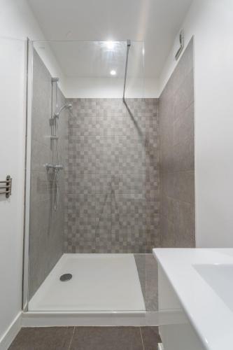 une salle de bain avec une douche avec une porte vitrée dans l'établissement Appartement Il Sereno - voyage entre les Pouilles et la Sicile, à Toulon