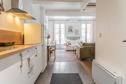 a kitchen with a counter and a living room at Appartement Il Sereno - voyage entre les Pouilles et la Sicile in Toulon