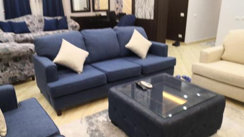 a living room with a blue couch and a coffee table at Alhejaz Luxurious Apartment in Cairo