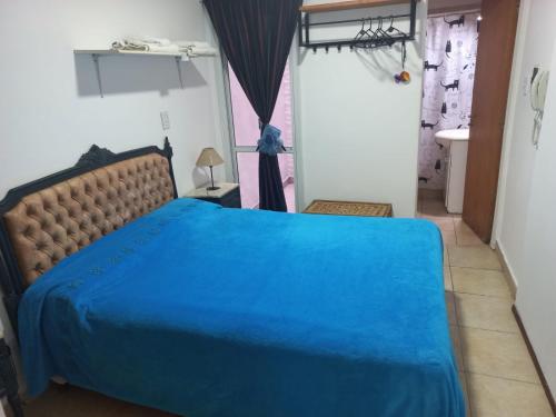 a bedroom with a blue bed in a room at Depto Luminoso 1 Dormitorio para 2 con Patio in Rosario