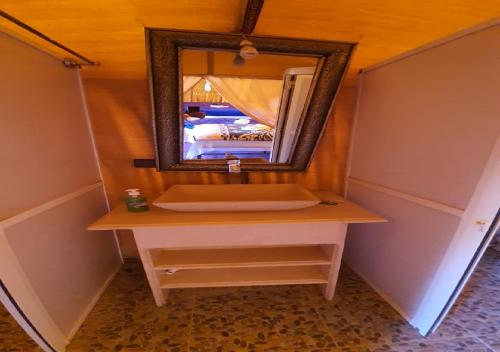 a bathroom with a sink and a mirror on a table at Luxury Desert Romantic Camp in Merzouga