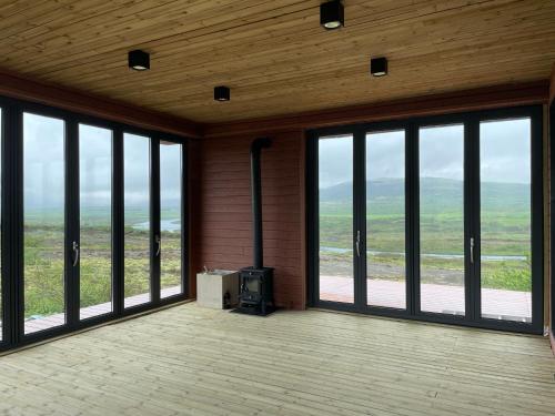 an empty room with large windows and a fireplace at Modern villa - in Golden Circle - Gullfoss Geysir Þingvöllur - Freyjustíg 13, 805 Selfoss in Búrfell