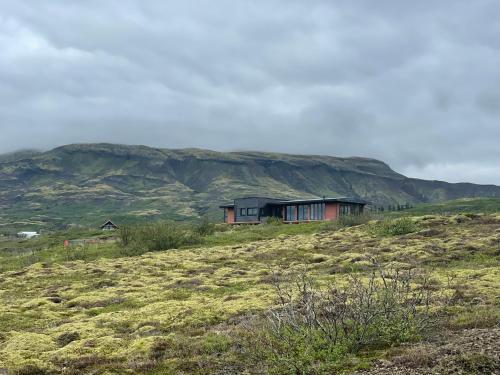 a house sitting on top of a grassy hill at Modern villa - in Golden Circle - Gullfoss Geysir Þingvöllur - Freyjustíg 13, 805 Selfoss in Búrfell