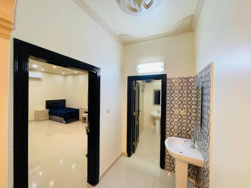 a room with a bathroom with a sink and a mirror at شقة واسعة بفناء خاص و دخول ذاتي in Al Madinah