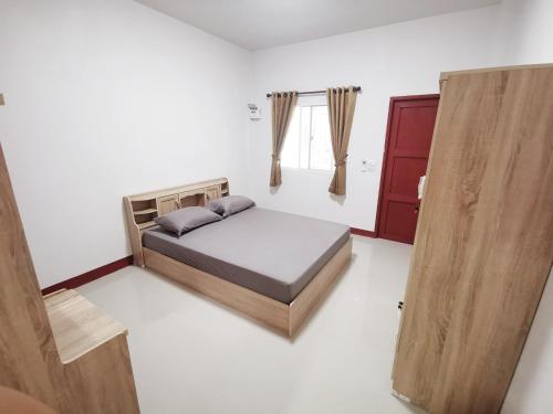 um quarto com uma cama e uma porta de madeira em ห้องเช่าพิภูตะวัน 