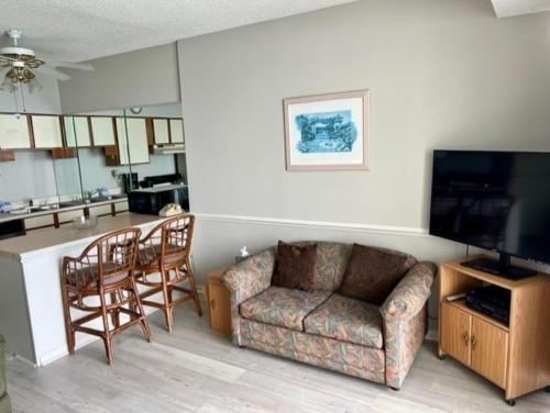 默特尔比奇ROYAL GARDEN RESORT 1510 condo的带沙发和椅子的客厅以及厨房。