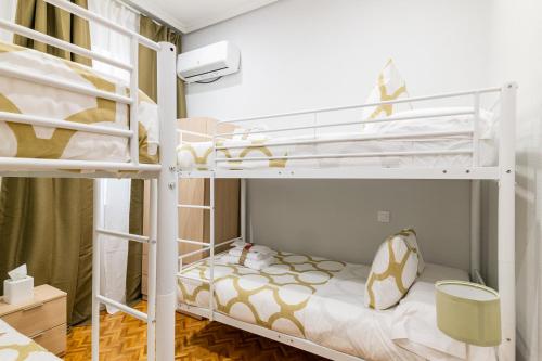Zimmer mit 2 Etagenbetten in einem Zimmer in der Unterkunft CENTRICO APARTAMENTO CON 3 BAÑOS EN PUERTA DEL SOL y ATOCHA in Madrid