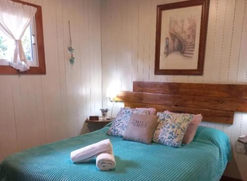a bedroom with a bed with towels on it at Tierras del Sur I un calido lugar in Villa La Angostura