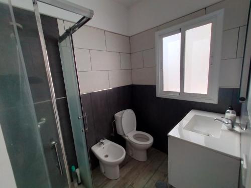 a bathroom with a toilet and a sink and a shower at Urban room in Las Lagunas