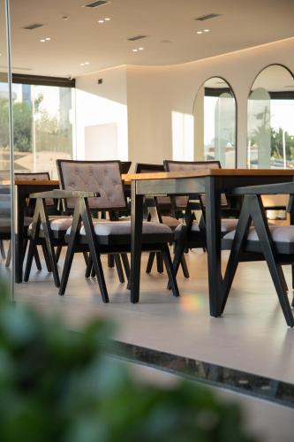 a dining room with a wooden table and chairs at Colosseum Hotel in Ksamil