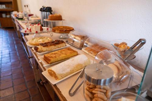 a buffet line with different types of bread and pastries at Pousada Rotunda in São João del Rei