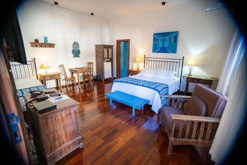 1 dormitorio con 1 cama, mesa y sillas en Pousada Rotunda en São João del Rei
